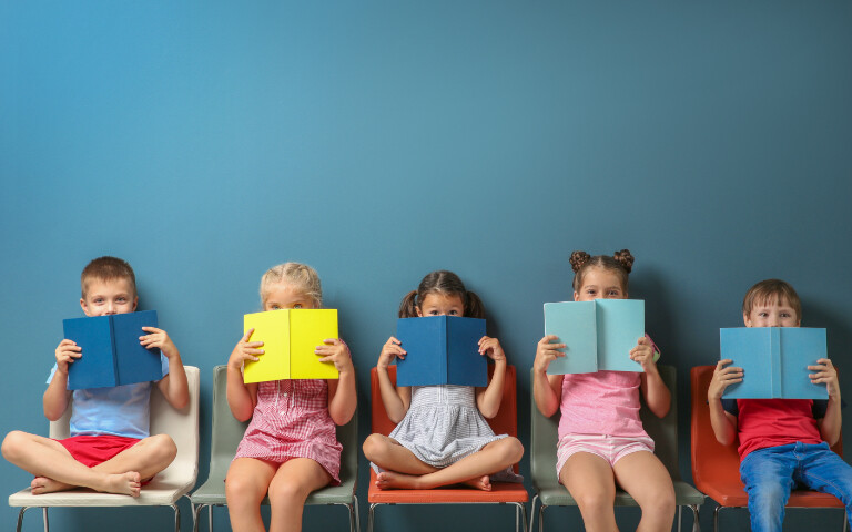 Ein Foto von 5 Kindern mit Schulbüchern in der Hand.